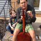 Eric showing his nephew how to string a guitar